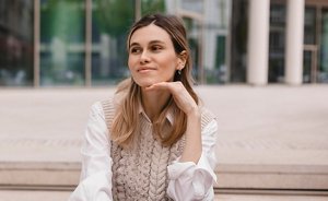 Professional woman with her brunette hair styled in a half up, half down ponytail